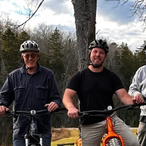 a group of people standing around a motorcycle